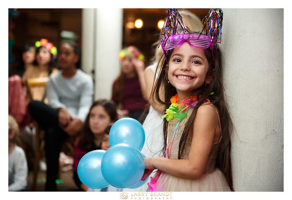 A young guest enjoying a celebration with balloons — Larry Brandt Photography