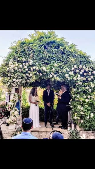 Nicki’s wedding beneath a flower-filled chuppah