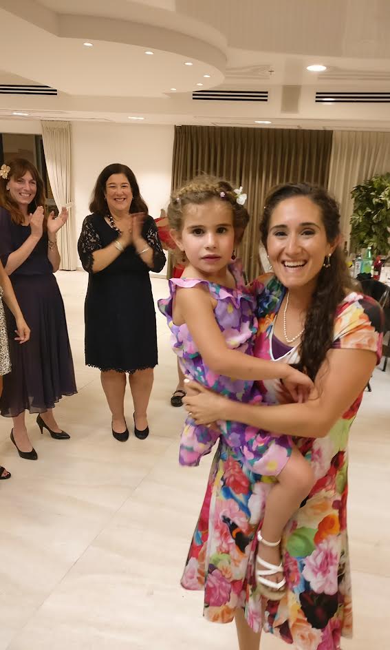 Tatiana holding a child at the celebration